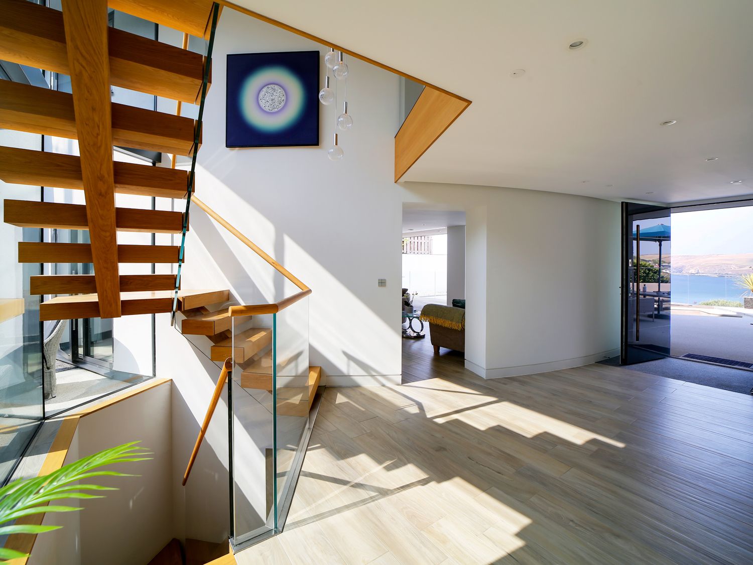 Open-plan interior with oak staircase and views towards the Cornish coast