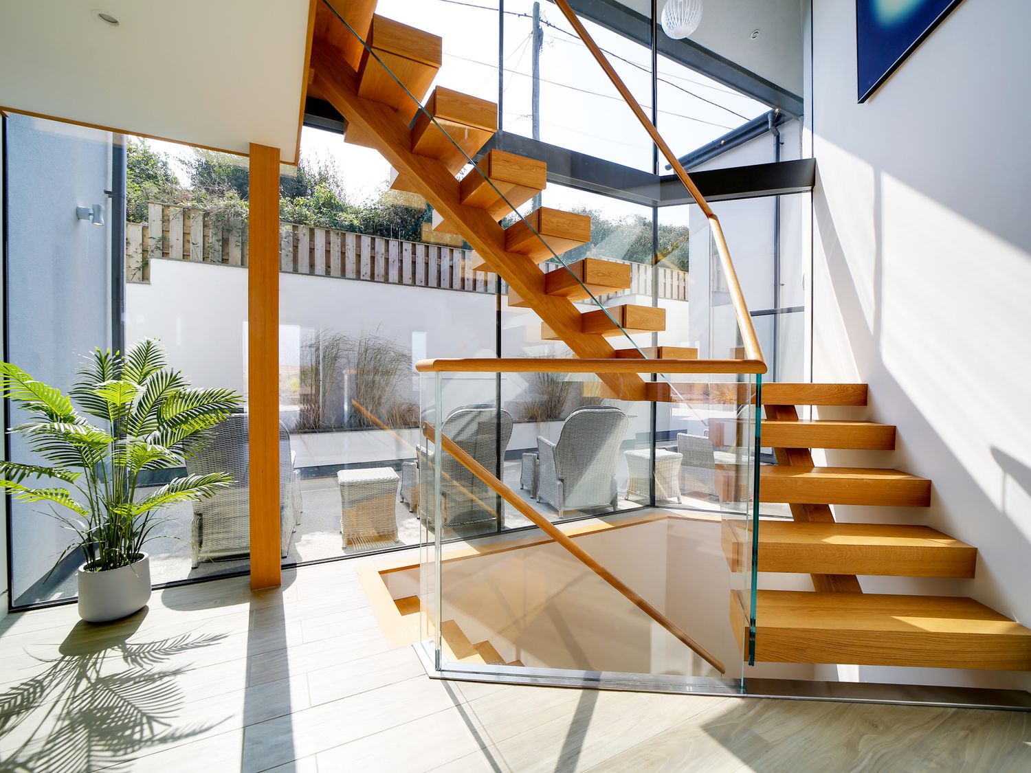 Oak feature staircase with glass balustrades and full-height glazing
